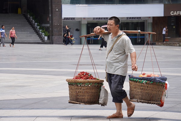 小贩挑着水果走过天奇广场，不紧不慢。