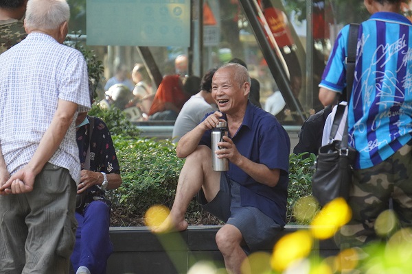 北碚步行街上闲坐的老人，手持茶杯开怀畅聊。